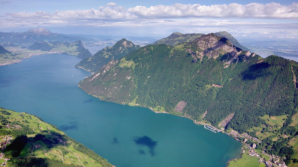 Lake Lucerne in summer daylight with wooded alpine ridges rising from both shores